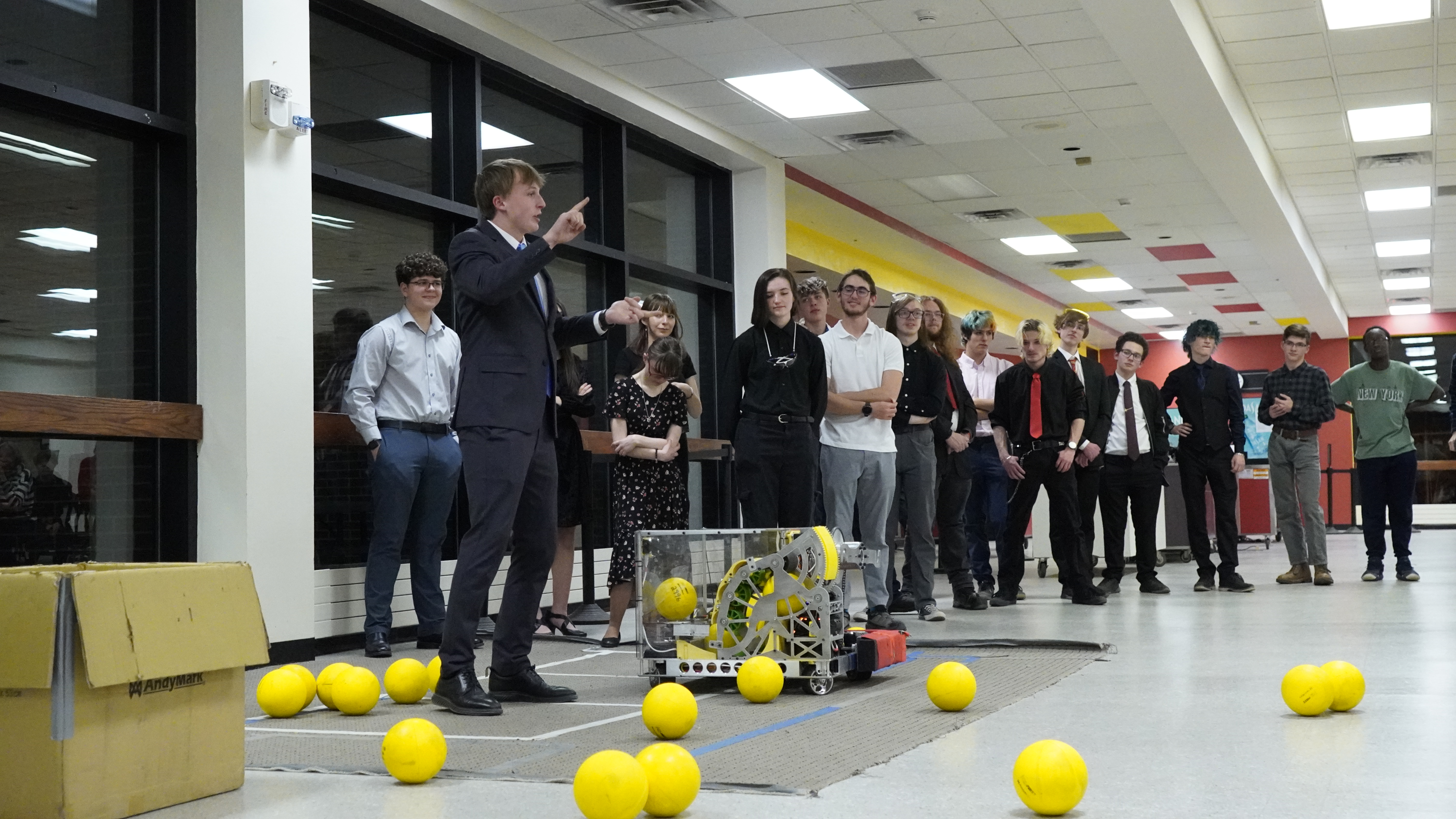 Photo of students displaying their robot to parents and sponsors.